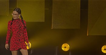 Movie still from “Ali Wong: Don Wong” (2022), directed by Nahnatchka Khan – A woman in a red dress standing in front of a yellow wall; Medium shot, Low angle