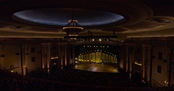 Movie still from “Ali Wong: Don Wong” (2022), directed by Nahnatchka Khan – A woman is standing on a stage in a theater; Extreme Wide shot, High angle