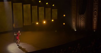 Movie still from “Ali Wong: Don Wong” (2022), directed by Nahnatchka Khan – A stage lit up with yellow lights in the middle of a show; Extreme Wide shot, High angle