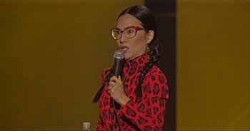 Movie still from “Ali Wong: Don Wong” (2022), directed by Nahnatchka Khan – A woman in a red and black dress holding a microphone; Close Up shot, Over the shoulder angle
