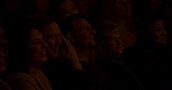 Movie still from “Ali Wong: Don Wong” (2022), directed by Nahnatchka Khan – A group of people sitting in a dark room; Medium shot, High angle