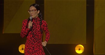 Movie still from “Ali Wong: Don Wong” (2022), directed by Nahnatchka Khan – A woman in a red dress holding a microphone; Medium shot, High angle