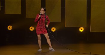 Movie still from “Ali Wong: Don Wong” (2022), directed by Nahnatchka Khan – A woman in a red dress holding a microphone on a stage; Wide shot, High angle