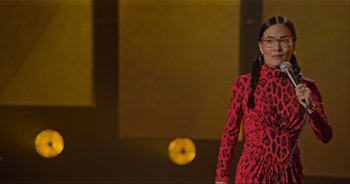 Movie still from “Ali Wong: Don Wong” (2022), directed by Nahnatchka Khan – A woman in a red and black leopard print dress; Medium shot, Low angle