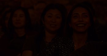 Movie still from “Ali Wong: Don Wong” (2022), directed by Nahnatchka Khan – Two women smiling for the camera in a dark room; Close Up shot, High angle