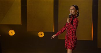 Movie still from “Ali Wong: Don Wong” (2022), directed by Nahnatchka Khan – A woman standing on a stage holding a microphone; Medium shot, Over the shoulder angle