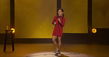 Movie still from “Ali Wong: Don Wong” (2022), directed by Nahnatchka Khan – A person in a red and black outfit holding a microphone on a stage; Extreme Wide shot, High angle