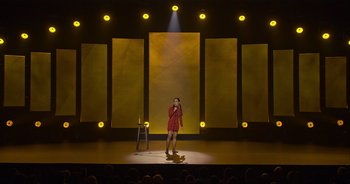 Movie still from “Ali Wong: Don Wong” (2022), directed by Nahnatchka Khan – A woman standing on a stage in front of a microphone; Extreme Wide shot, High angle