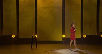 Movie still from “Ali Wong: Don Wong” (2022), directed by Nahnatchka Khan – A woman standing on a stage holding a microphone; Extreme Wide shot, High angle
