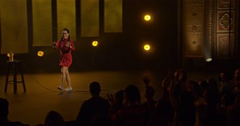 Movie still from “Ali Wong: Don Wong” (2022), directed by Nahnatchka Khan – A woman in a red dress taking a picture with a cell phone; Extreme Wide shot, High angle
