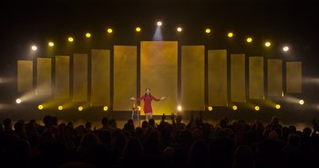 Movie still from “Ali Wong: Don Wong” (2022), directed by Nahnatchka Khan – A woman standing on a stage in front of an audience; Extreme Wide shot, Low angle