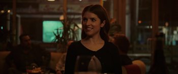 Movie still from “Alice, Darling” (2022), directed by Mary Nighy – A woman sitting at a table with a glass of wine in front of her; Close Up shot, Over the shoulder angle