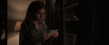 Movie still from “Alice, Darling” (2022), directed by Mary Nighy – A woman holding an envelope in her hands; Medium shot, Over the shoulder angle