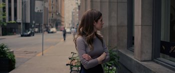 Movie still from “Alice, Darling” (2022), directed by Mary Nighy – A woman standing on the side of the street with her arms crossed; Medium shot, Over the shoulder angle