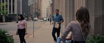 Movie still from “Alice, Darling” (2022), directed by Mary Nighy – A man walking down the street while holding a paper bag; Wide shot, Over the shoulder angle