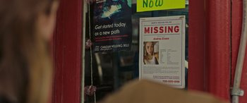 Movie still from “Alice, Darling” (2022), directed by Mary Nighy – A missing person sign hanging in a store window; Extreme Close Up shot, High angle