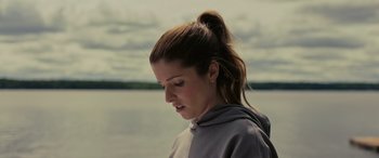 Movie still from “Alice, Darling” (2022), directed by Mary Nighy – A person wearing a hoodie near a body of water; Close Up shot, Low angle