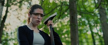 Movie still from “Alice, Darling” (2022), directed by Mary Nighy – A woman holding an axe in a forest; Close Up shot, Over the shoulder angle