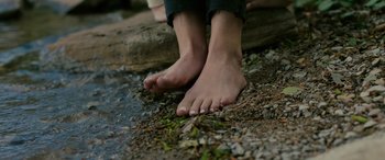 Movie still from “Alice, Darling” (2022), directed by Mary Nighy – A person's bare feet on the ground near some water; Extreme Close Up shot, High angle
