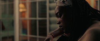 Movie still from “Alice, Darling” (2022), directed by Mary Nighy – A woman with a headscarf is looking at the camera; Close Up shot, Low angle