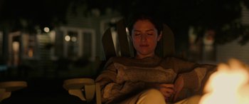 Movie still from “Alice, Darling” (2022), directed by Mary Nighy – A woman sitting in a chair looking at her phone; Medium shot, High angle