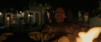 Movie still from “Alice, Darling” (2022), directed by Mary Nighy – A woman sitting in a chair with her eyes closed; Medium shot, Low angle
