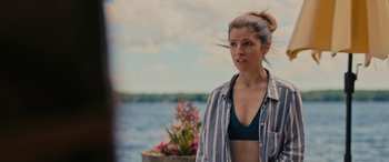 Movie still from “Alice, Darling” (2022), directed by Mary Nighy – A beautiful young woman standing next to a body of water; Medium shot, Over the shoulder angle