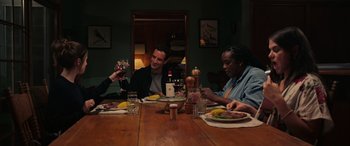 Movie still from “Alice, Darling” (2022), directed by Mary Nighy – A group of people sitting at a dinner table; Medium shot, High angle