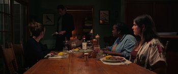 Movie still from “Alice, Darling” (2022), directed by Mary Nighy – Two people sitting at a table with plates of food on it; Medium shot, High angle