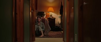 Movie still from “Alice, Darling” (2022), directed by Mary Nighy – A woman sitting on the ground in a room; Wide shot, High angle