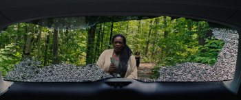 Movie still from “Alice, Darling” (2022), directed by Mary Nighy – A woman holding a book in the back of a car; Medium shot, Over the shoulder angle
