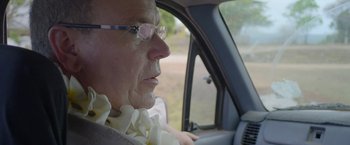 Movie still from “Alick and Albert” (2021), directed by Douglas Watkin – An older man driving a car in a field; Close Up shot, Over the shoulder angle