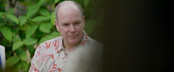 Movie still from “Alick and Albert” (2021), directed by Douglas Watkin – A man with a shaved head wearing a hawaiian shirt; Close Up shot, Over the shoulder angle
