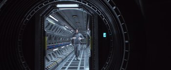 Movie still from “Alien: Covenant” (2017), directed by Ridley Scott – A man walking down a hallway in a building; Wide shot, Low angle