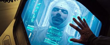 Movie still from “Alien: Covenant” (2017), directed by Ridley Scott – A man in a white suit is looking at a futuristic screen; Extreme Close Up shot, Overhead angle