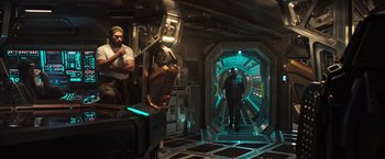 Movie still from “Alien: Covenant” (2017), directed by Ridley Scott – A man standing inside of a room next to another man; Wide shot, High angle