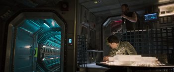 Movie still from “Alien: Covenant” (2017), directed by Ridley Scott – A man sitting at a table in a room; Wide shot, High angle