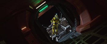 Movie still from “Alien: Covenant” (2017), directed by Ridley Scott – A man in a yellow suit standing on a platform; Wide shot, Overhead angle