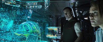 Movie still from “Alien: Covenant” (2017), directed by Ridley Scott – A man standing next to an interactive screen; Medium shot, Over the shoulder angle