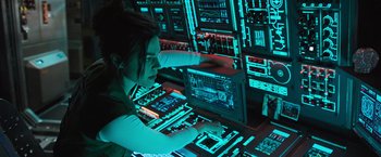 Movie still from “Alien: Covenant” (2017), directed by Ridley Scott – A woman working on a computer in front of a bunch of screens; Medium shot, Over the shoulder angle