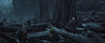 Movie still from “Alien: Covenant” (2017), directed by Ridley Scott – Two people standing next to a tree in a dark forest; Wide shot, Low angle