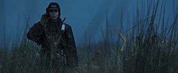 Movie still from “Alien: Covenant” (2017), directed by Ridley Scott – A person in a field with a gun in their hand; Medium shot, Low angle