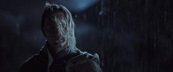 Movie still from “Alien: Covenant” (2017), directed by Ridley Scott – A man with long blonde hair is standing in the dark; Close Up shot, Low angle