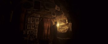 Movie still from “Alien: Covenant” (2017), directed by Ridley Scott – A man standing in a dark room next to a wall; Wide shot, High angle