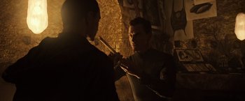 Movie still from “Alien: Covenant” (2017), directed by Ridley Scott – A man holding a pair of drum sticks in front of another man; Medium shot, Over the shoulder angle