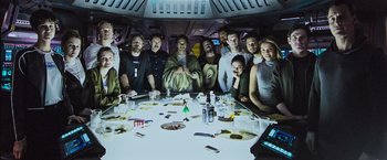 Movie still from “Alien: Covenant” (2017), directed by Ridley Scott – A group of people sitting around a dinner table; Wide shot, Overhead angle