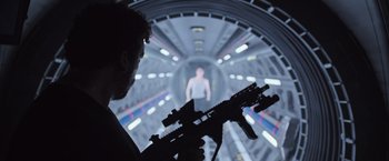 Movie still from “Alien: Covenant” (2017), directed by Ridley Scott – A man holding a gun in a room with lights; Medium shot, Over the shoulder angle