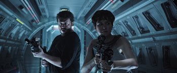 Movie still from “Alien: Covenant” (2017), directed by Ridley Scott – A man and a woman holding guns in a room; Medium shot, Low angle