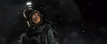 Movie still from “Alien: Covenant” (2017), directed by Ridley Scott – A woman in a space suit is standing in the snow; Medium shot, Low angle