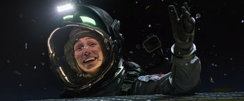 Movie still from “Alien: Covenant” (2017), directed by Ridley Scott – A man in a space suit is smiling for the camera; Close Up shot, Overhead angle